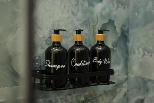 vier flessen wijn op een plank in de badkamer bij Mia Napoli in Napels