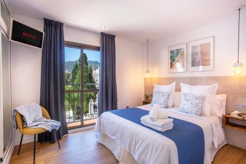 a bedroom with a large bed with a window at Pueblo Evita in Benalmádena