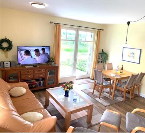 - un salon avec un canapé et une télévision dans l'établissement Ferien Wohnungen Arkonablick, à Juliusruh