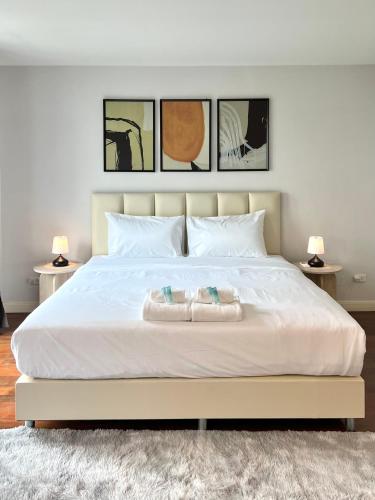 a bedroom with a large white bed with two pillows at Entire 3BR Townhome, Pool, Sukhumvit, BTS&MRT Asok in Bangkok