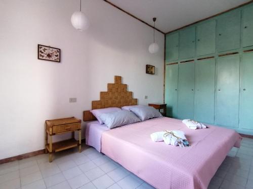 1 Schlafzimmer mit 2 Betten und rosa Bettwäsche in der Unterkunft Vacanze degli Sposi in Fregene