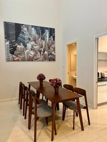 a dining room table with chairs and a painting on the wall at Entire 3BR Townhome, Pool, Sukhumvit, BTS&MRT Asok in Bangkok
