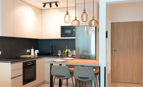 una cocina con mesa y 4 sillas. en Luxury by Wave, en Siófok