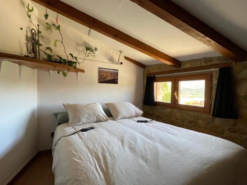 a bedroom with a white bed with a window at Casa de Lilith in Aren