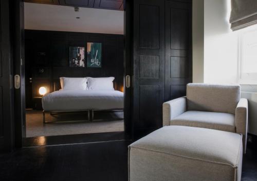 - une chambre avec un lit et une chaise dans l'établissement Numa London Bloomsbury, à Londres