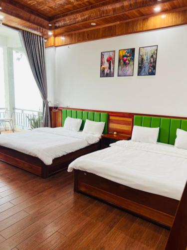 two beds in a room with green and white at Ruby Tam Đảo in Tam Ðảo