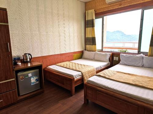 a small room with two beds and a tv at Star Hotel in Cat Ba