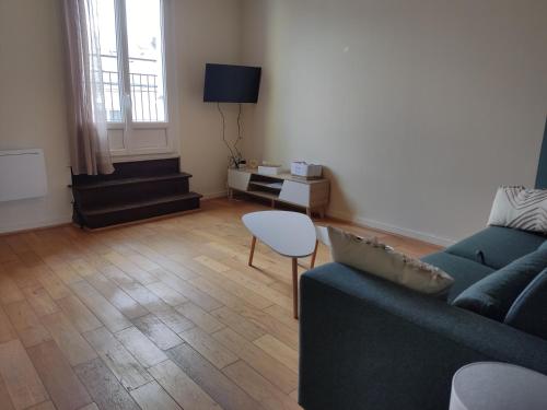 una sala de estar con un sofá y una mesa en Le charme Centre Parking wifi, en Châteauroux