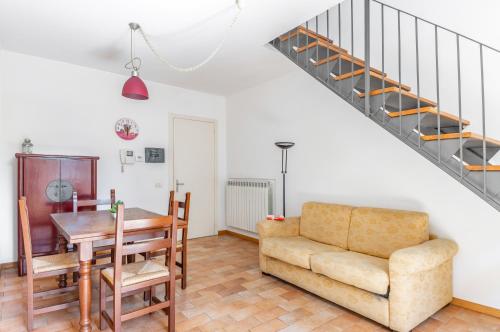 uma sala de estar com um sofá, uma mesa e uma escada em Perugia Tranquil Hideaway Apartment! em Perugia