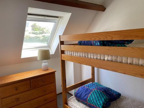 une chambre avec un lit superposé et une fenêtre dans l'établissement Maison paisible, piscine, plages à 500m, à Clohars-Carnoët