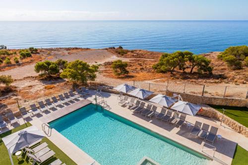 una vista aérea de una piscina con sillas y el océano en Blue Line Apartment Hotel en Villajoyosa