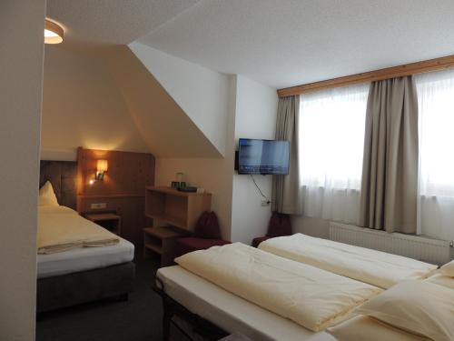 a hotel room with two beds and a television at Haus Christophorus in Obergurgl