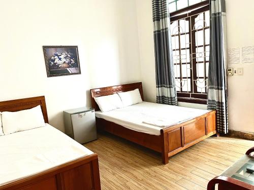 1 dormitorio con 2 camas y ventana en Sofia Tống Duy Tân, en Sầm Sơn
