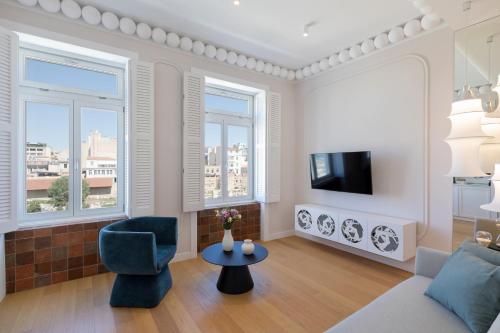 - un salon avec un canapé, une télévision et des fenêtres dans l'établissement Agora Suites, à Athènes