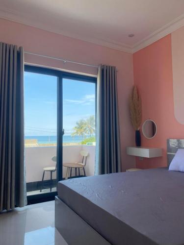 a bedroom with a bed and a view of the ocean at Pink Sea Villa in Cu Lao Thu