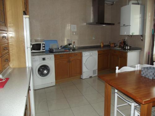 a kitchen with a washing machine and a washer at Pensión Sandoval in León