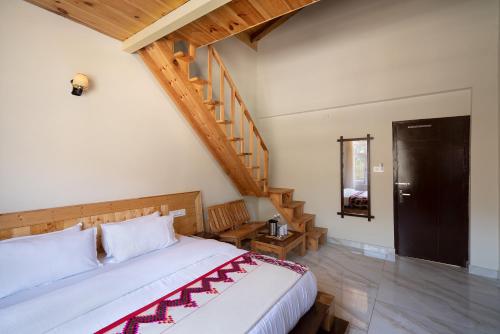 1 dormitorio con 1 cama y escalera de madera en The Dargeli's Lodge, Manali en Haripūr
