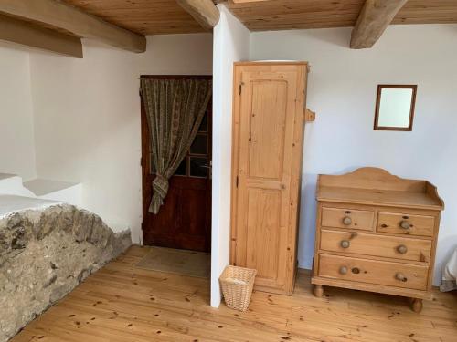 a bedroom with a bed and a dresser and a door at Secluded & Charming Gîte Surrounded by Nature in Désaignes