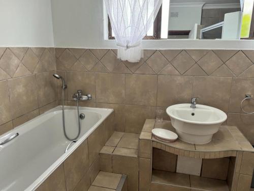 a bathroom with a sink and a bath tub at Ocean Vista in Amanzimtoti