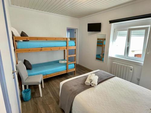 sypialnia z 2 łóżkami piętrowymi i krzesłem w obiekcie Granny´s Guesthouse w mieście Praia de Mira