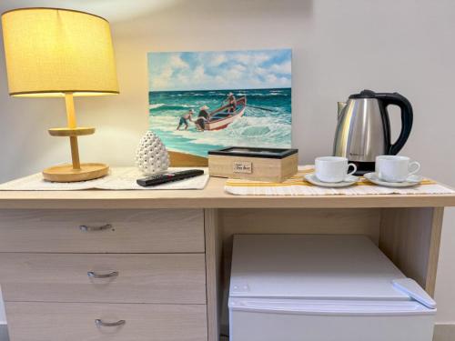 a desk with a lamp and a picture of a boat in the ocean at Vicoletto Fiorito in Porto Empedocle