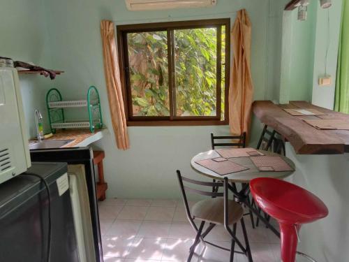 a kitchen with a small table and a window at kamrai resort apartment in Ban Bang Bao