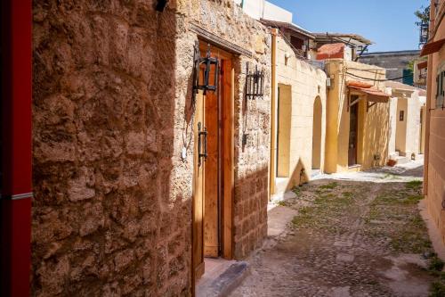 eine Gasse in einer Altstadt mit offener Tür in der Unterkunft Casa Ifestou in Rhodos (Stadt)