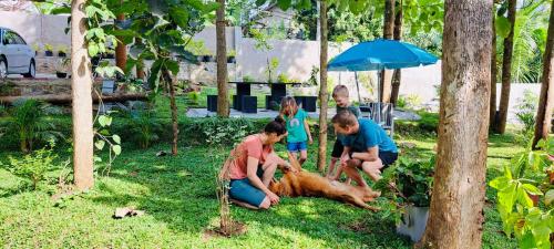 een groep mensen die een hond aaien in het gras bij Villa Sole in Kandy