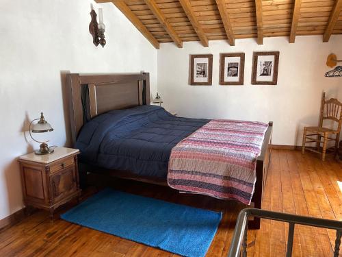 a bedroom with a bed with a blue comforter at Casa Pollard in Marvão