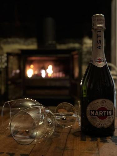 a bottle of champagne next to two glasses on a table at East Lodge - Chillingham Castle in Alnwick