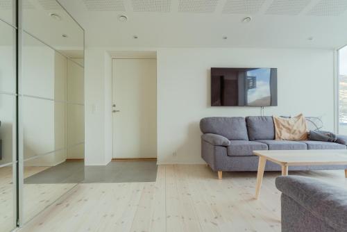 a living room with a couch and a table at Seaside Nest - Charming Waterfront Retreat in Vestmanna