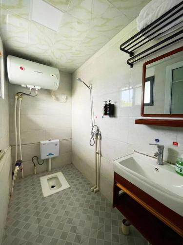 a bathroom with a sink and a toilet in it at 云起山居庭院观景民宿 in Fenghuang