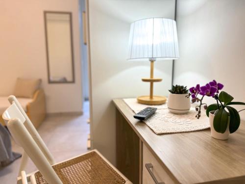 Cette chambre comprend un bureau avec une lampe et des fleurs violettes. dans l'établissement Vicoletto Fiorito, à Porto Empedocle