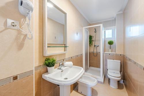 La salle de bains est pourvue d'un lavabo, de toilettes et d'une douche. dans l'établissement CARIHUELA - Beach & Sun, à Torremolinos