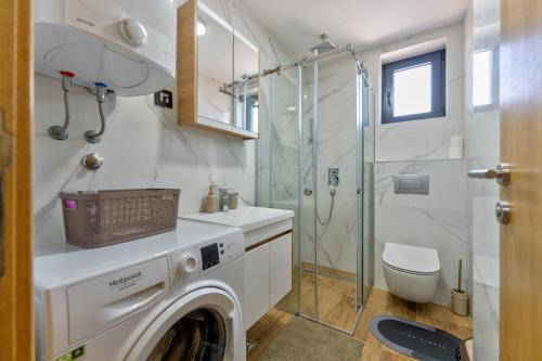 a washing machine in a bathroom with a shower at Akik in Zlatibor
