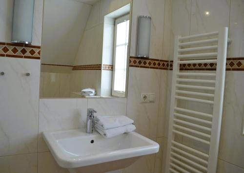 a white bathroom with a sink and a mirror at Insel Landhaus Seaside in Gager