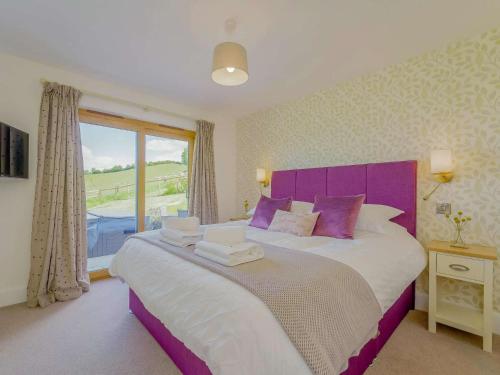 a bedroom with a large bed with a purple headboard at 2 Bed in Montgomery 83243 in Llandyssil