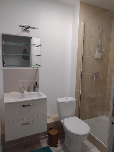 uma casa de banho com um WC, um chuveiro e um lavatório. em Appartement indépendant Ô Bohème em Fourqueux