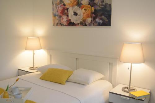 a bedroom with a white bed with two lamps at Charmante Zimmer Wohnung Stilvoll in Münster