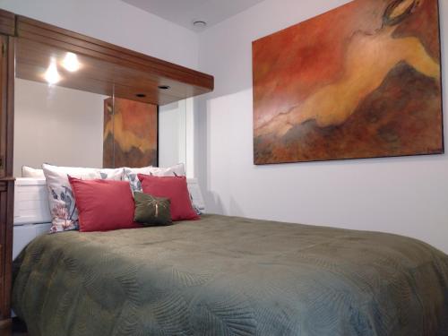 um quarto com uma cama com um quadro na parede em Appartement indépendant Ô Bohème em Fourqueux