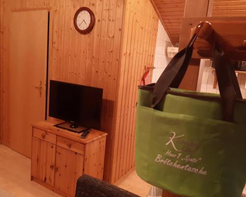 a living room with a green bag and a tv at Ferienhaus Spatz 1 