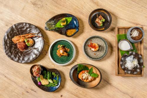 a group of plates of food on a table at Devasom Khao Lak Beach Resort & Villas in Khao Lak