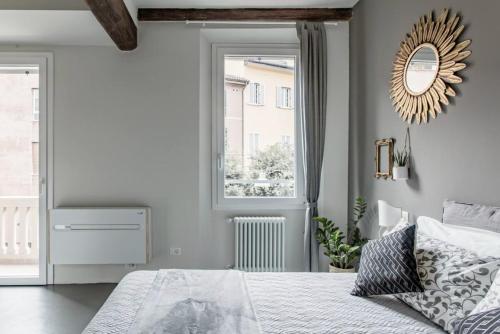 Charming flat Righi Bologna في بولونيا: غرفة نوم بسرير ومرآة ونافذة