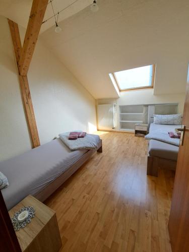 - une chambre mansardée avec 2 lits et une fenêtre dans l'établissement Wohnung mit 2 Zimmern, à Ballenberg