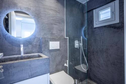 a bathroom with a toilet and a sink and a mirror at Serenity Seafront garden villa in Pefkohori