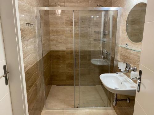 y baño con ducha y lavamanos. en Penzion Trödler, en Brod nad Dyjí