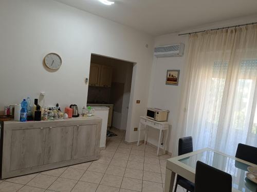 een keuken met een aanrecht en een klok aan de muur bij L'appartamento delle vacanze in Venturina Terme