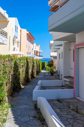 a walkway between buildings with the ocean in the background at Serenity Seafront garden villa in Pefkohori