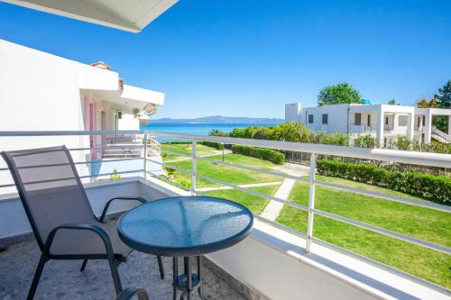 a balcony with a table and chairs and the ocean at Serenity Seafront garden villa in Pefkohori