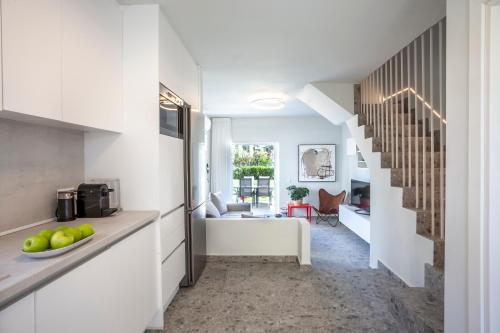 a kitchen with a staircase and a living room at Serenity Seafront garden villa in Pefkohori